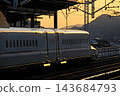 An N700 series Shinkansen departing the station before dawn. 143684793