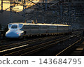 An N700 series Shinkansen departing the station before dawn. 143684795