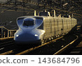 An N700 series Shinkansen passing through the station before dawn. 143684796