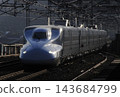 An N700 series Shinkansen passing through the station before dawn. 143684799