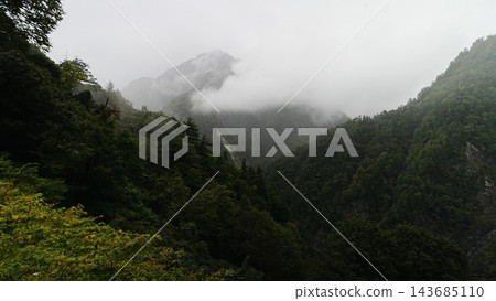 秋季的黑部峽谷,遠處奧金山的山坡聳立在前景的樹木和濃霧之外。 秋季的黑部峽谷,遠處奧金山的山坡聳立在前景的樹木和濃霧之外。 143685110