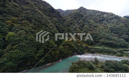 秋季,黑部川流經黑部峽谷,樹葉翠綠,山坡景色優美。 秋季,黑部川流經黑部峽谷,樹葉翠綠,山坡景色優美。 143685111