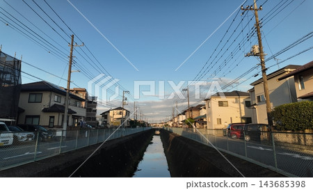 黃昏時分,埼玉縣一處居民區內的水道和街道景觀。 黃昏時分,埼玉縣一處居民區內的水道和街道景觀。 143685398