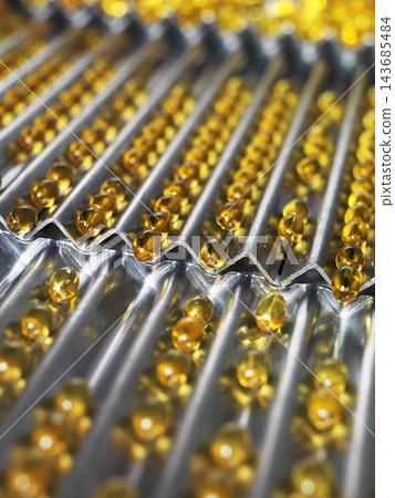 Vitamin Softgel Capsules on Pharmaceutical Production Tray 143685484