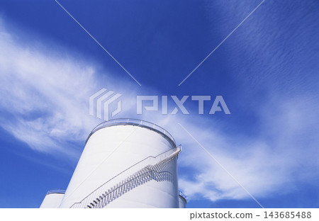 White Industrial Storage Tank Under Blue Cloudy Sky 143685488