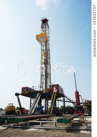 Oil Drilling Rig at Industrial Energy Site Under Blue Sky Oil Drilling Rig at Industrial Energy Site Under Blue Sky 143685707