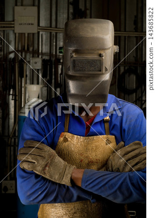 Welder in Protective Mask Standing in Industrial Workshop Welder in Protective Mask Standing in Industrial Workshop 143685822