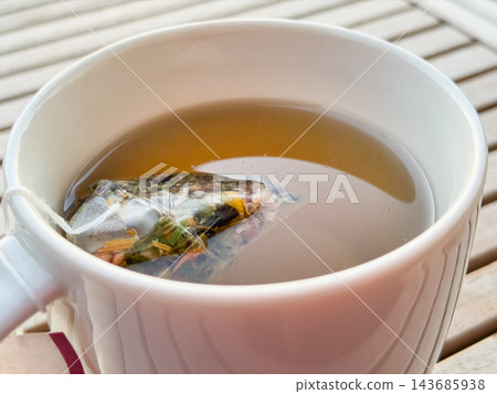 花草茶的特寫。茶包裡裝有乾燥花草,例如洋甘菊。 花草茶的特寫。茶包裡裝有乾燥花草,例如洋甘菊。 143685938