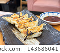 Fried dumplings with a slightly burnt crust. Served with dipping sauce. 143686041