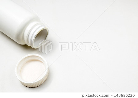 An open white plastic medicine bottle with its cap beside it, set against a clean white background, ideal for healthcare and pharmaceutical concepts. An open white plastic medicine bottle with its cap beside it, set against a clean white background, ideal for healthcare and pharmaceutical concepts. 143686220