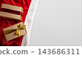 Christmas background with two gift boxes wrapped in kraft paper, one with a red ribbon and one with a gold bow, on a red and white Santa hat against a light grey surface. Concept of Merry Christmas 143686311