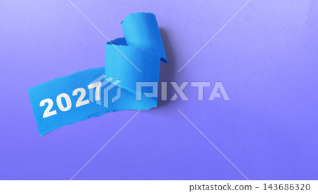 Blue torn paper with the year 2027 written on it, isolated on a purple background. Concept of Happy New Year 143686320