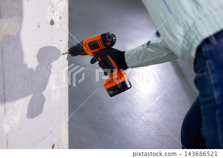 一名男子在建築工地上拿著工具。 一名男子在建築工地上拿著工具。 143686521
