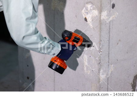 一名男子在建築工地上拿著工具。 143686522