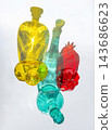 Colorful Glass Bottles and Pomegranate with Vibrant Light Reflections 143686623