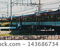 Everyday scenes of cyclists waiting for a train at a railroad crossing. 143686734