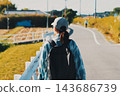 The back view of a person walking through a rural landscape 143686739