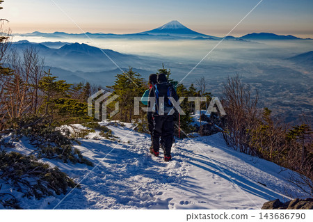 冬季,一名登山者在八嶽山脈的三頭山脊上,遠眺富士山。 冬季,一名登山者在八嶽山脈的三頭山脊上,遠眺富士山。 143686790