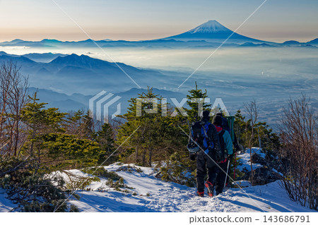 冬季,一名登山者在八嶽山脈的三頭山脊上,遠眺富士山。 冬季,一名登山者在八嶽山脈的三頭山脊上,遠眺富士山。 143686791