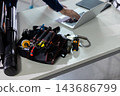 A male worker's hands operating a computer at a construction site. 143686799