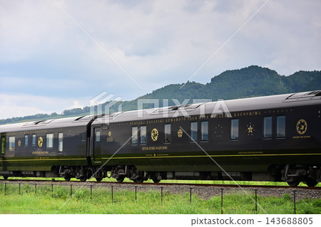 JR九州的豪華遊輪列車「九州七星號」穿梭於鬱鬱蔥蔥的鄉村風景之中。 JR九州的豪華遊輪列車「九州七星號」穿梭於鬱鬱蔥蔥的鄉村風景之中。 143688805