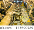 High angle view of a massive marine diesel engine inside vessel engine room with steel pipelines and stairs. 143690589