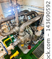 High angle view of a powerful marine turbocharger system with heavy insulated pipelines inside vessel engine room. 143690592