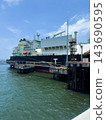 Large LNG carrier vessel berthed at specialized offshore gas terminal during cargo loading operations. 143690595