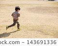 A boy running around energetically in the park 143691336