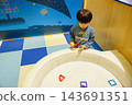 A boy engrossed in educational toys indoors. 143691351