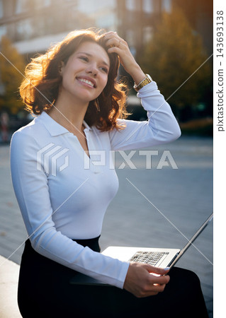 Beauty woman smiling while working on laptop outdoors. Beautiful woman presenting confident professional lifestyle with portable computer. Flexible career concept. 143693138