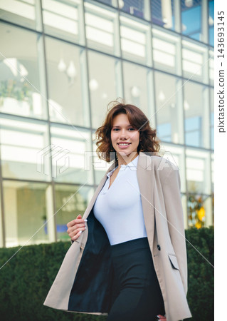 Attractive woman walking confidently in elegant business blazer outdoors. Beautiful woman enjoying modern corporate lifestyle near office. Career success concept. 143693145