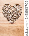 Heart shaped sunflower seeds on wood surface 143693709