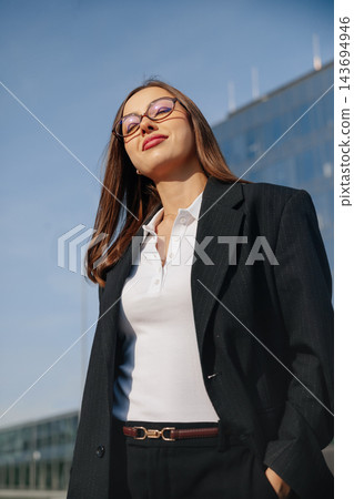 Beautiful Business Woman Portrait Looking Up Near Modern Office Building Wearing Black Suit And White Shirt. Corporate Lifestyle Concept Female Professional Urban 143694946
