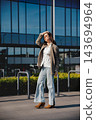 Young Woman Adjusting Hair Near Modern Office Building Wearing Beige Blazer. Casual Business Lifestyle Concept Female Urban Style 143694964