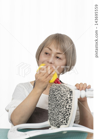 一位老婦人在客廳裡改造了一個娃娃椅，作為她的DIY愛好。 143695559