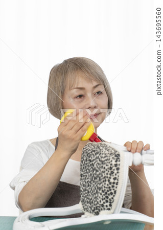 一位老婦人在客廳裡改造了一個娃娃椅,作為她的DIY愛好。 一位老婦人在客廳裡改造了一個娃娃椅,作為她的DIY愛好。 143695560