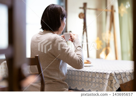 中老年婦女在客廳享受下午茶時光。 中老年婦女在客廳享受下午茶時光。 143695657