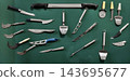 Cheese knives and serving tools arranged on a green surface for food preparation 143695677