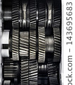 Metal helical gears inside a mechanical gearbox during an industrial machine inspection 143695683