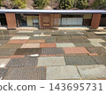 A modern Japanese-style building with a stone-paved water basin and wooden lattice work. 143695731