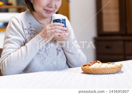 中老年婦女在客廳享受下午茶時光。 143695807