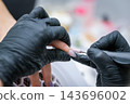 Professional care at a personal care studio focuses on a manicure, fingernails, a manicurist, an electric nail drill, a nail drill, electric nail file, and a nail technician 143696002