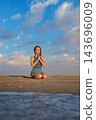 Beach scene featuring a woman, yoga, vajrasana, thunderbolt pose, meditating, and prayer pose 143696009