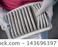 A woman shows a dirty car engine air filter. 143696397