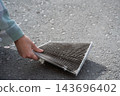 A woman shows a dirty car cabin air filter. 143696402