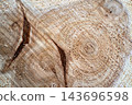 Wood log cut surface with tree rings, cracks, and grain close up 143696598