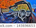 The lightweight sports car interior of a Porsche 981 Boxster Spyder surrounded by autumn foliage. 143696653