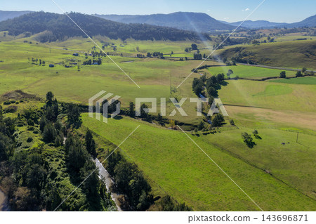 Aerial view of green farmland, wooded hills and a winding river in Lambs Valley, Hunter Valley, New South Wales, Australia. 143696871