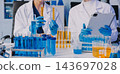 Medical or scientific researcher or man doctor looking at a test tube of clear solution in a laboratory 143697028